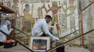 A field school trainee cleans a chapel wall at Khonsu Temple at Karnak in Luxor.