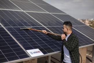 Staff clean and maintain the newly installed rooftop solar panels at Baby Center Company, a small Gazan garments manufacturer. With power cuts for up to 16 hours per day, alternative energy is often the only option for Gazan businesses. As the owner of Baby Center Company, Sulaiman Deeb knew he needed reliable electricity when he reopened his business in the wake of COVID-19.