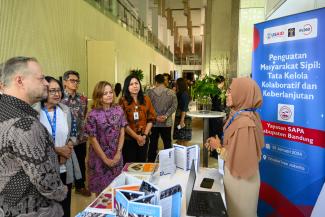 Wakil Direktur Misi USAID Indonesia Erin Nicholson bertemu dengan salah satu mitra masyarakat sipil, Yayasan SAPA dari Kabupaten Bandung, di pameran yang menampilkan mitra OMS USAID MADANI.