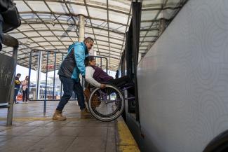 A woman participates in an accessibility assessment of the Quite Trole bus stop