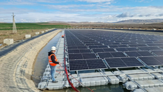 A man installs a floating solar panel