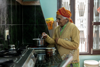 A woman brews tea at an electric cookstove