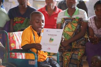 A child sitting in his wheelchair and reading a book