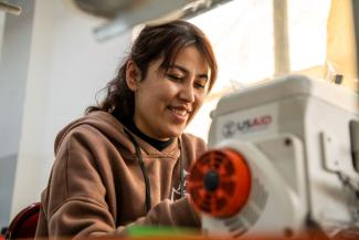 lady is working on a sewing machine