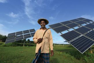 Bangladeshi farmer using solar power for irrigation in his rice field