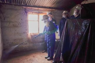 An Indoor Residual Spray technician sprays the inside of a home to protect against malaria.