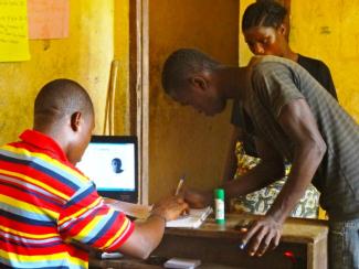 Filling out voter registration paperwork at a voter's registration center in Central Liberia