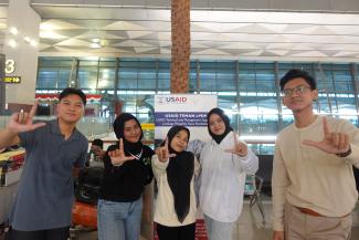 A group of Indonesian university students pose at the airport while traveling to study in the United States.