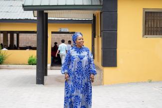 Woman wearing blue dress standing in front of factory