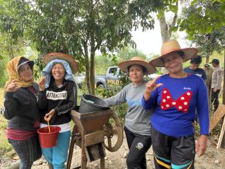 Women coffee farmers with a coffee bean sheller