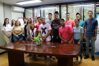 A group of Dominican university students look at the camera and smile.