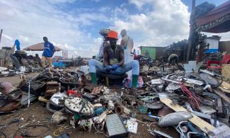 Young man working on discarded electronic appliances