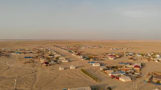 A village near the Aral Sea showing surrounding dry land and houses.