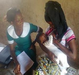 Madam Kusumi Gipi (right) practices proper positioning and attachment during a breastfeeding counseling session with a local community health worker. 