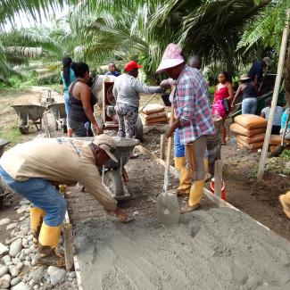 Community members work on constructing a pathway. Photo Credit: OTI Grantee