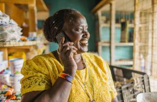 A woman smiles while talking on a cell phone