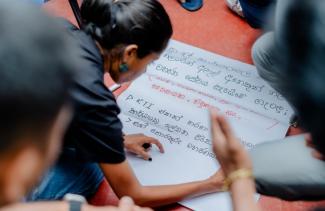 Woman writing on a sheet of paper participating in a workshop 