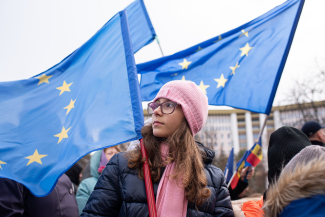 A girl waves an EU flag in a parade.