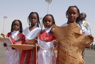 Four girls hold a hand-written sign