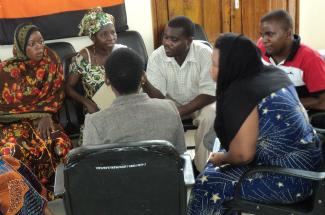 A group of people sit in a circle discussing information on rights and legislation