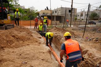 Construction workers install sewer lines through the USAID-supported Jericho Wastewater project