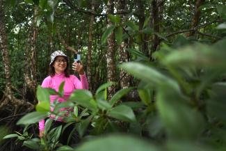 A woman takes a photo of a tree in the Philippines