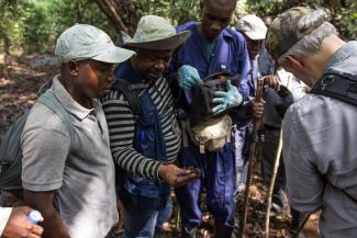 A group of people huddle around measuring equipment