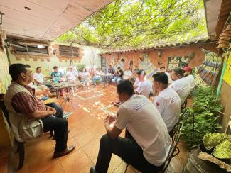 Men sitting in workshop. 