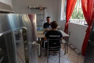 A couple sitting in the kitchen and talking and making plans for their business.