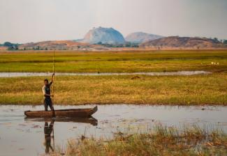 A fisherman navigates the wetlands of the Cubango-Okavango River Basin, where conservation efforts aim to protect biodiversity and support local communities.