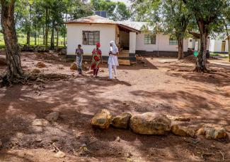 Nurse Jalia walking with her patients outside the health facility