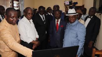 Officials from the Cameroon Ministry of Public Health and various stakeholders observing the online system for enrolling beneficiaries in Universal Health Coverage during the Phase launch ceremony on April 12 2023 MS