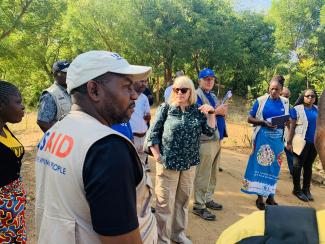 USAID Mission Director Pamela Fessenden interacts with community members after a site visit to southern Malawi where vulnerable communities heavily felt the impacts of El Nino and are now engaged in resilience building activities which restore their degraded environment. Photo: Oris Chimenya/USAID