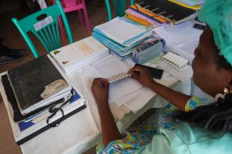 Photo of nurse with Free medication available through Universal Health Coverage initiative RISE USAID PEPFAR MSH Cameroon