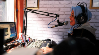 A woman speaks into a microphone. Credit:Denny Herlambang Slamet, Internews