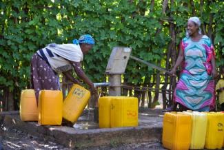 Women fill their containers with water from a pump built under a USAID water and sanitation project in Ethiopia. Photo credit: AECOM.