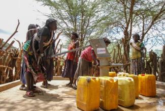 This woman in Era pumps water from a well built under a USAID water and sanitation project in Ethiopia. Photo credit: AECOM.