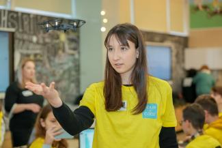 A girl with a drone hovering over her hand