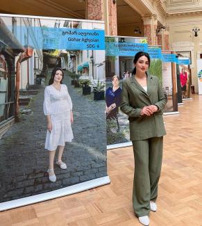 a woman stands in front of a printed display