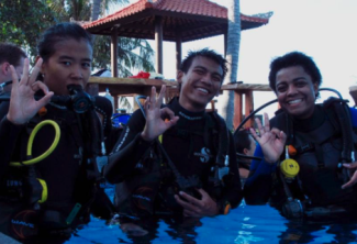 Three people wearing scuba gear in a pool