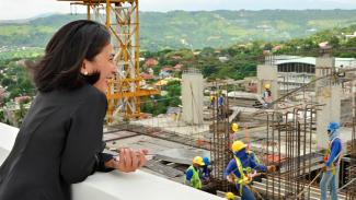 Woman looking over building construction.