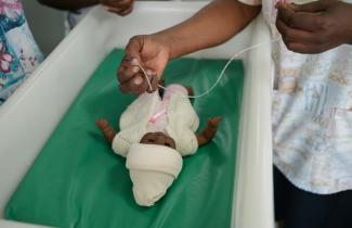 Infant doll in a crib.