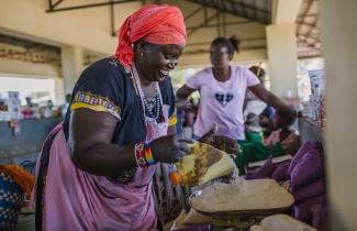 A woman measures flour on a scale in a market