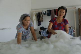 Woman and child processing wool.