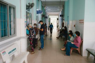 A hospital hallway with patients waiting in line.