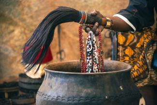 A hand is holding instruments used in traditional healing ceremonies.