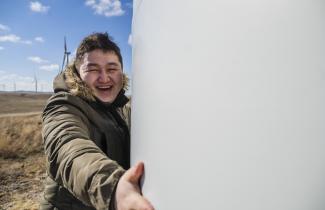 A man holding the base of a wind turbine