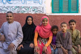 A man and woman sit side by side with their four children.