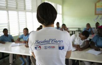 A person shows the back of their t-shit, which says "Baseball Cares"