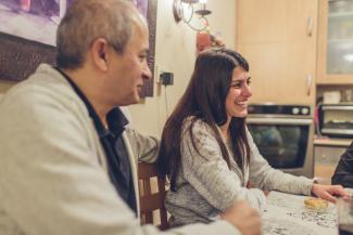 Liraz and her family sit down together for a meal in their home.